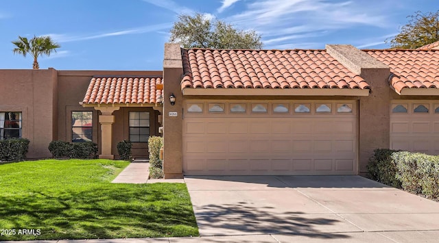 view of front of house with a garage, concrete driveway, stucco siding, a tile roof, and a front yard