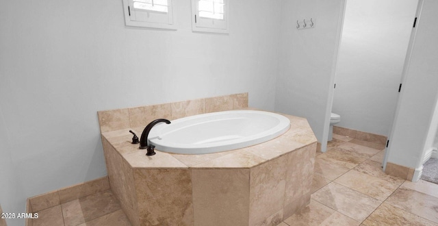 bathroom with tiled tub and toilet