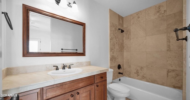 full bathroom with tiled shower / bath, vanity, and toilet