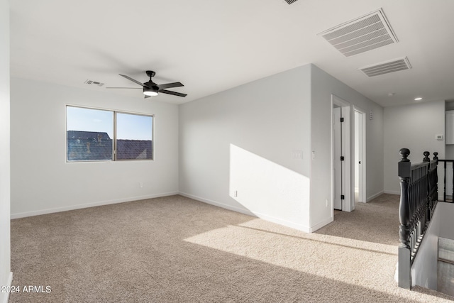 carpeted spare room featuring ceiling fan