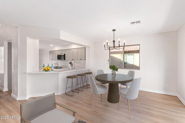 dining area featuring a chandelier and light hardwood / wood-style flooring