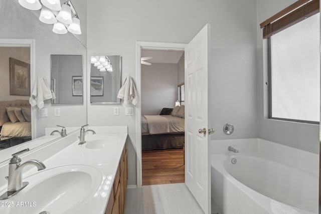 bathroom featuring a sink, double vanity, connected bathroom, and a bath