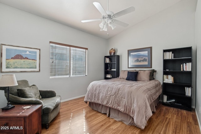 bedroom with ceiling fan, baseboards, vaulted ceiling, and wood finished floors