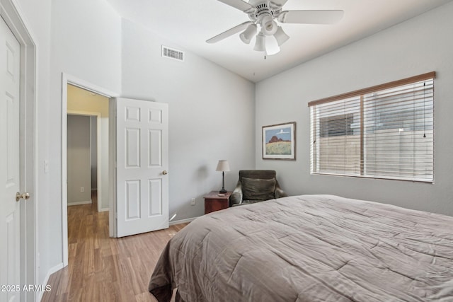 bedroom featuring a ceiling fan, wood finished floors, visible vents, and baseboards