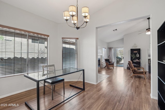 office area with a fireplace, wood finished floors, visible vents, baseboards, and vaulted ceiling