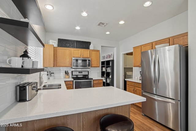 kitchen with decorative backsplash, a peninsula, stainless steel appliances, open shelves, and a sink