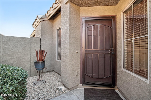 doorway to property featuring stucco siding