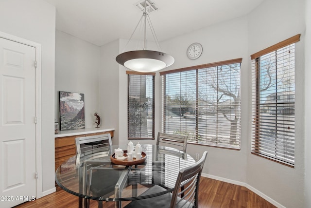 dining area with wood finished floors, visible vents, and baseboards