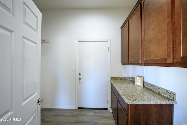 kitchen with wood-type flooring and light stone counters