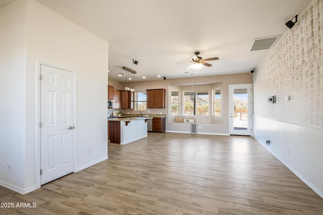 unfurnished living room with ceiling fan and light hardwood / wood-style floors