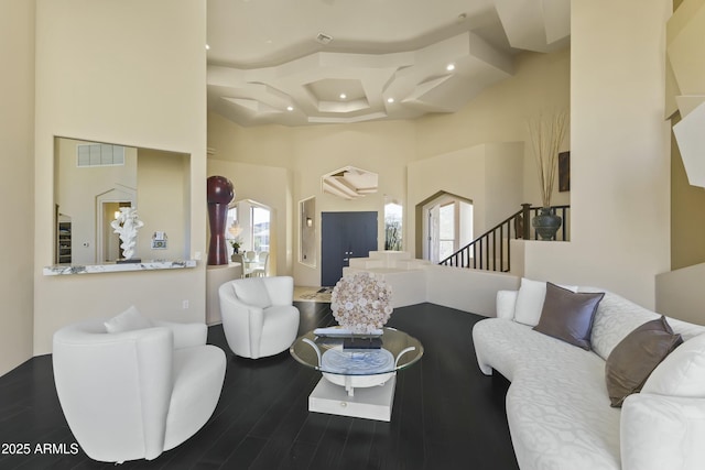 living room with a towering ceiling and hardwood / wood-style flooring