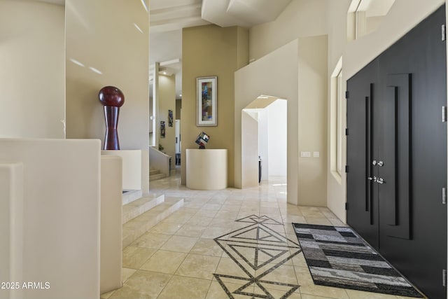 tiled foyer with a high ceiling