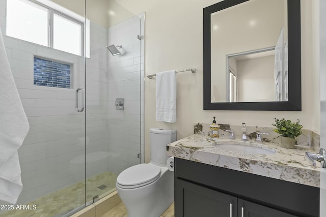 bathroom with vanity, toilet, and a shower with shower door