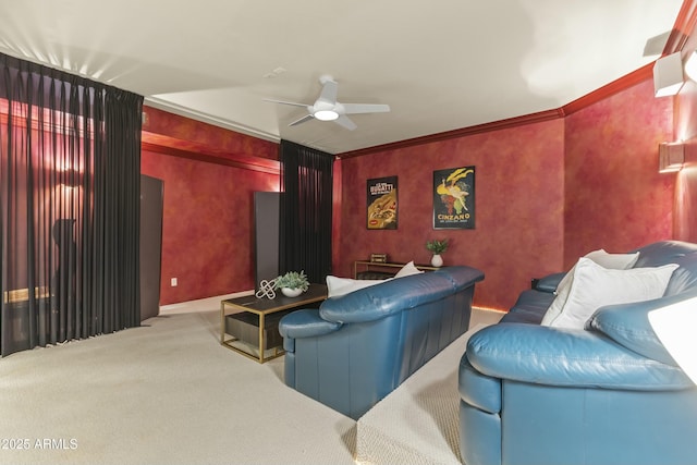 home theater room with light colored carpet, ceiling fan, and crown molding