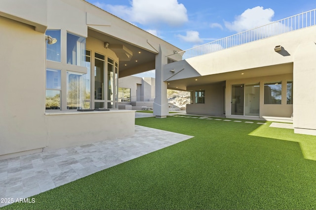 back of house with a yard and a patio