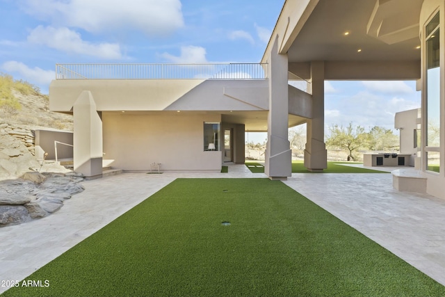 back of house with a yard, a balcony, and a patio area