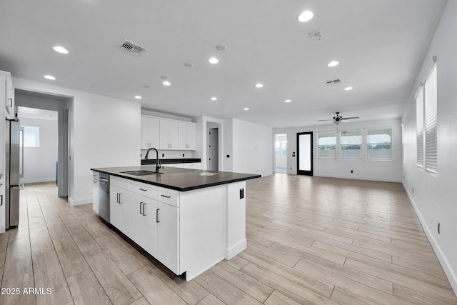 kitchen featuring ceiling fan, white cabinetry, a center island with sink, and sink