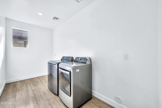 washroom featuring light hardwood / wood-style floors and washer and clothes dryer