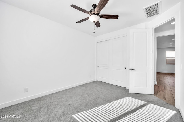 unfurnished bedroom featuring ceiling fan, a closet, and carpet