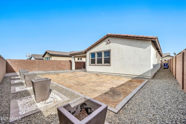 rear view of property with a patio area and an outdoor fire pit