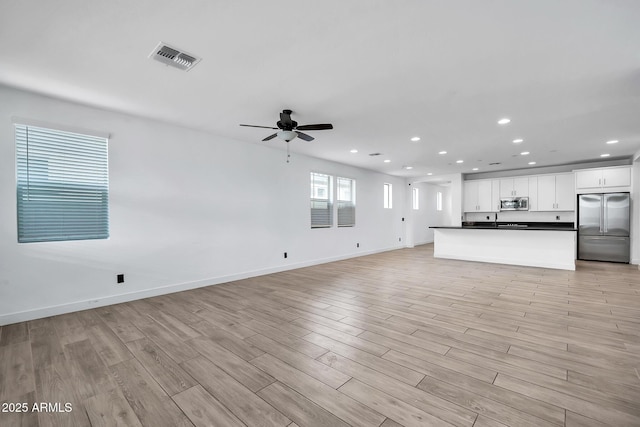 unfurnished living room with ceiling fan and light hardwood / wood-style flooring