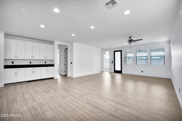 unfurnished living room featuring ceiling fan and light hardwood / wood-style flooring