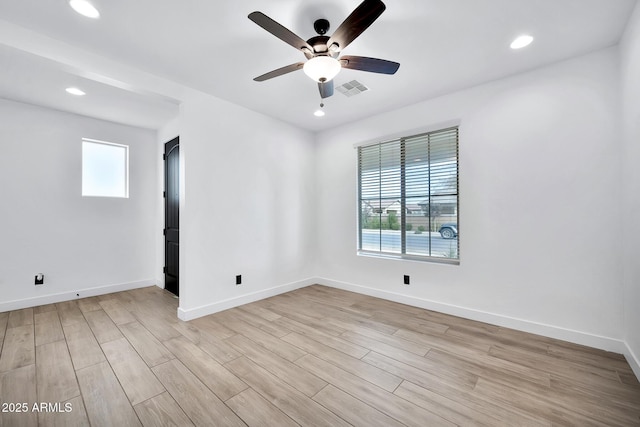 empty room with ceiling fan and light hardwood / wood-style flooring