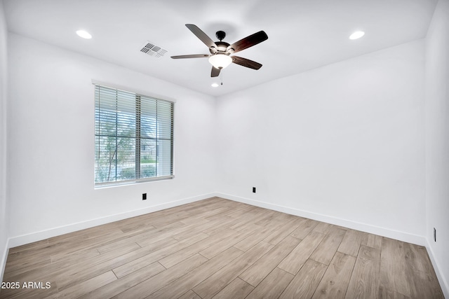 empty room with ceiling fan and light hardwood / wood-style flooring