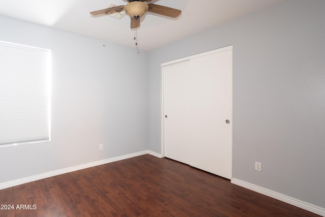 empty room with ceiling fan and dark hardwood / wood-style flooring