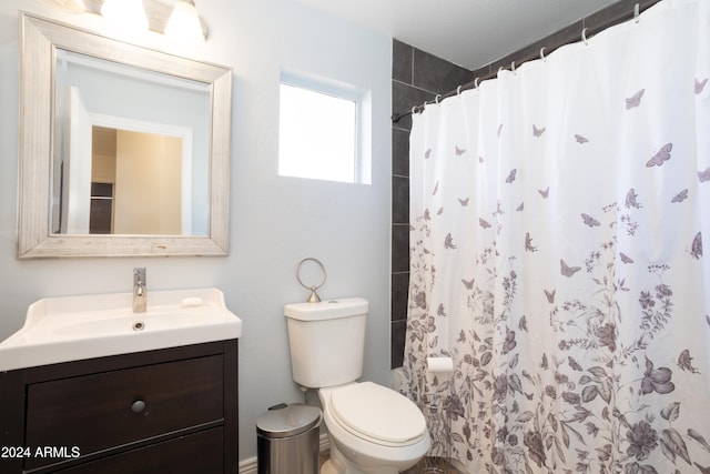 bathroom with curtained shower, vanity, and toilet