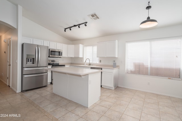 kitchen with white cabinetry, hanging light fixtures, appliances with stainless steel finishes, and vaulted ceiling