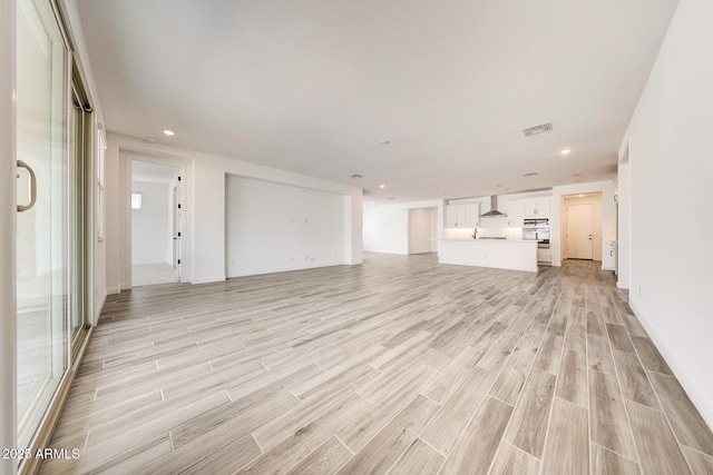 14742 W Lariat Trl, Surprise, AZ 85387 - unfurnished living room featuring light wood-type flooring, recessed lighting, baseboards, and a sink