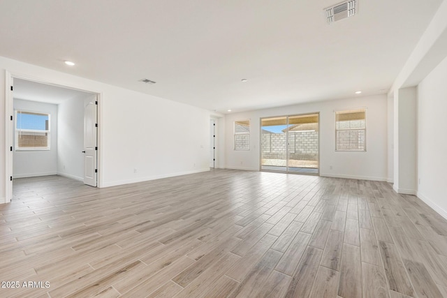 14742 W Lariat Trl, Surprise, AZ 85387 - unfurnished living room with light wood-style flooring, healthy amount of natural light, baseboards, and recessed lighting