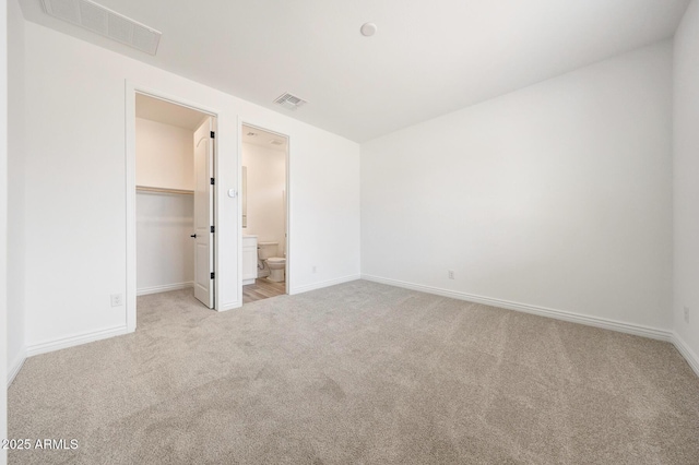 14742 W Lariat Trl, Surprise, AZ 85387 - unfurnished bedroom featuring carpet, a walk in closet, baseboards, a closet, and connected bathroom