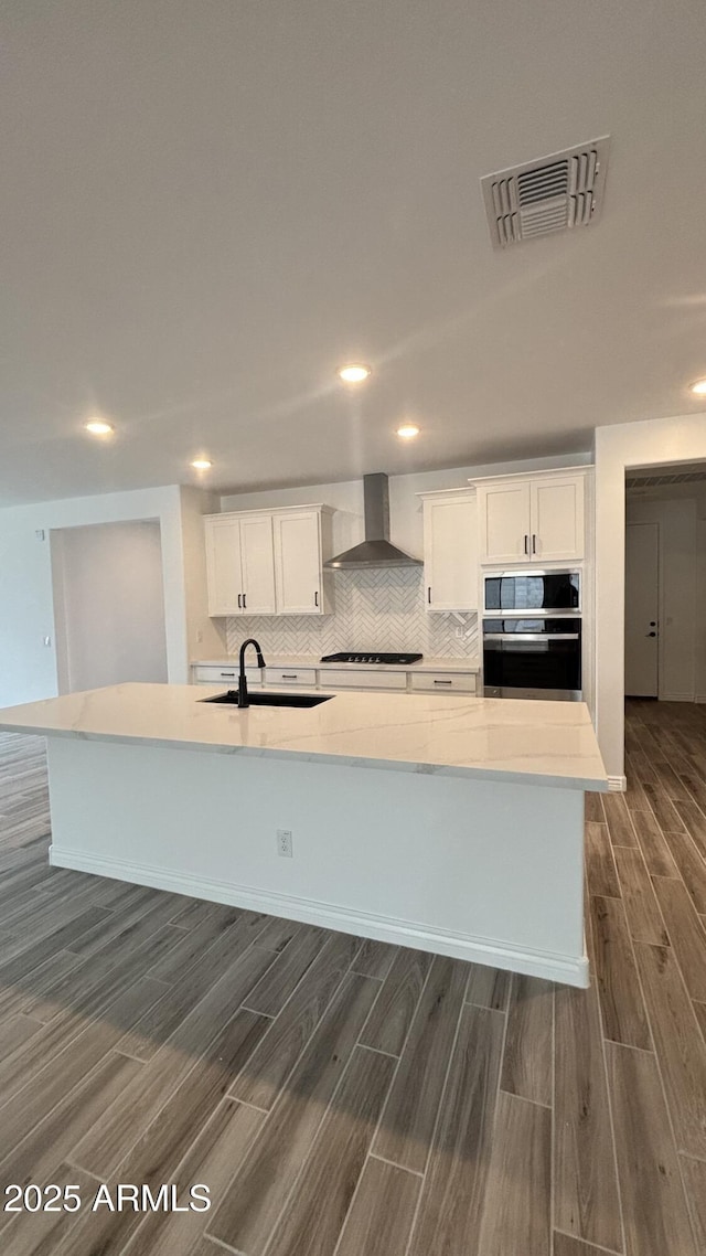 14742 W Lariat Trl, Surprise, AZ 85387 - kitchen with stainless steel oven, wall chimney range hood, a sink, wood tiled floors, and a large island