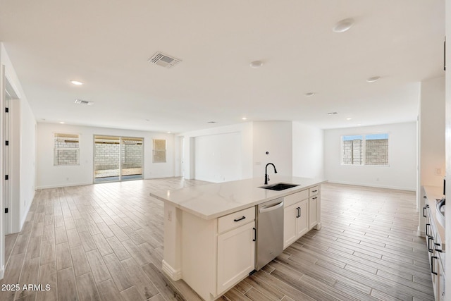 14742 W Lariat Trl, Surprise, AZ 85387 - kitchen featuring open floor plan, stainless steel dishwasher, a sink, light wood-style flooring, and a center island with sink
