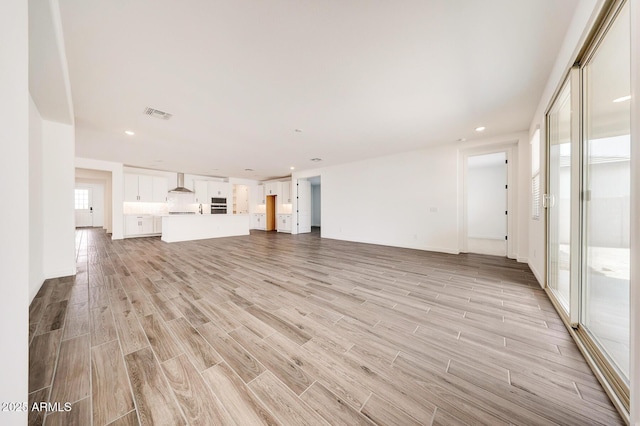 14742 W Lariat Trl, Surprise, AZ 85387 - unfurnished living room featuring light wood-type flooring and recessed lighting