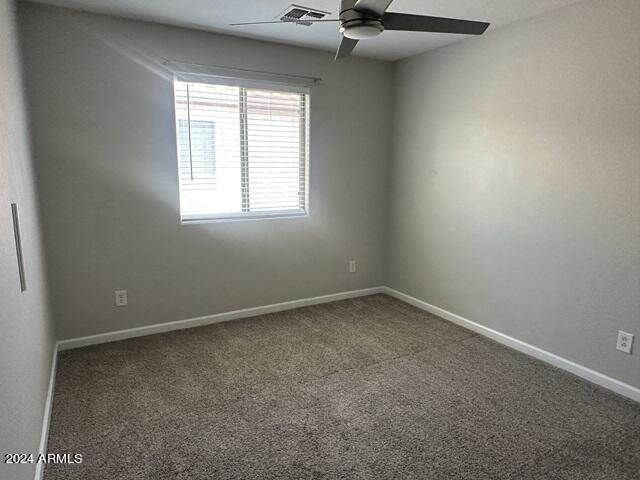 carpeted spare room featuring ceiling fan