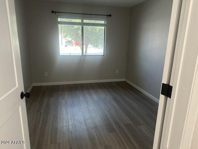 unfurnished room with dark hardwood / wood-style flooring