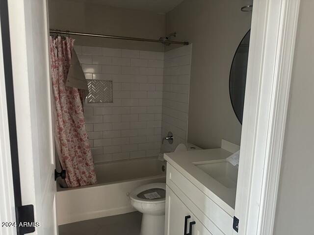 full bathroom featuring shower / bath combination with curtain, vanity, and toilet