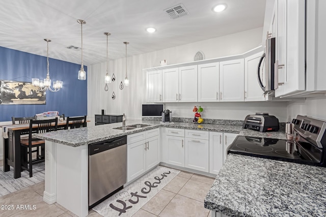 kitchen with sink, white cabinets, hanging light fixtures, kitchen peninsula, and stainless steel appliances