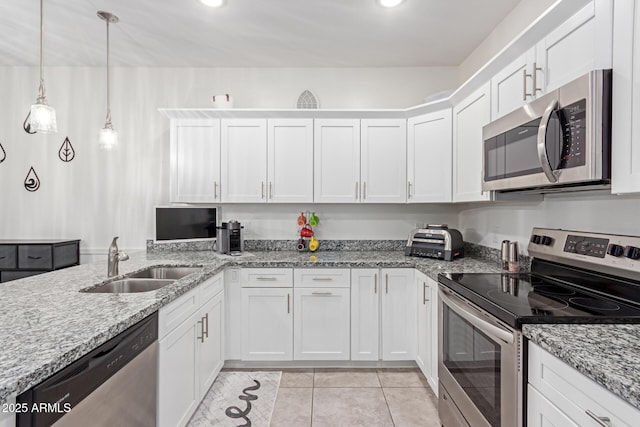 kitchen with appliances with stainless steel finishes, sink, hanging light fixtures, and white cabinets