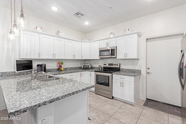 kitchen with appliances with stainless steel finishes, sink, white cabinets, and kitchen peninsula