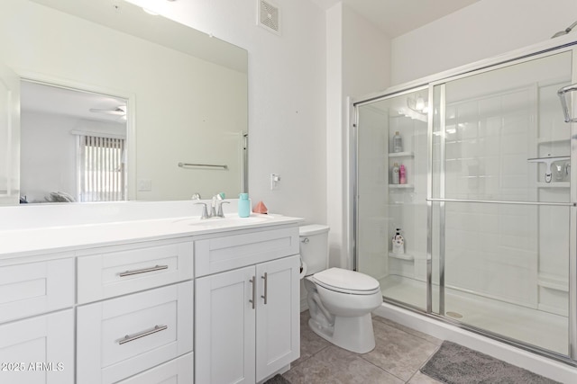 bathroom with tile patterned flooring, vanity, walk in shower, and toilet