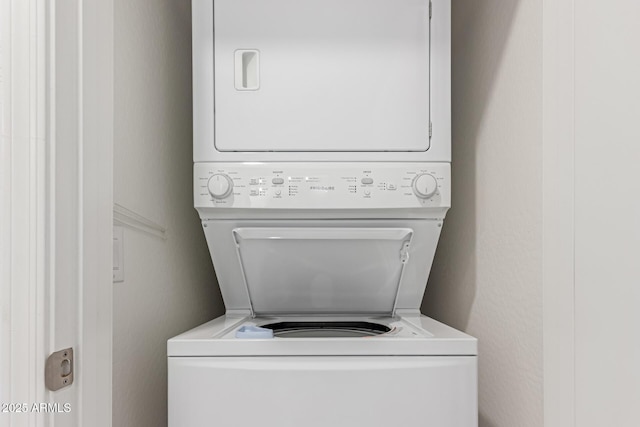 clothes washing area with stacked washer and clothes dryer