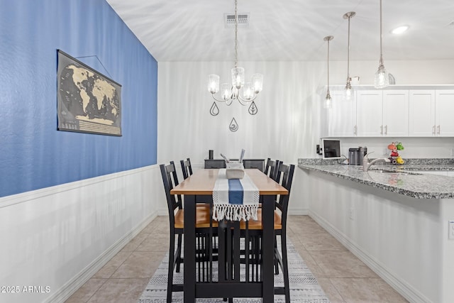 dining area featuring an inviting chandelier, sink, and light tile patterned flooring