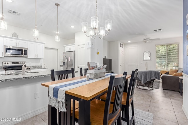 dining space featuring light tile patterned floors, sink, and ceiling fan