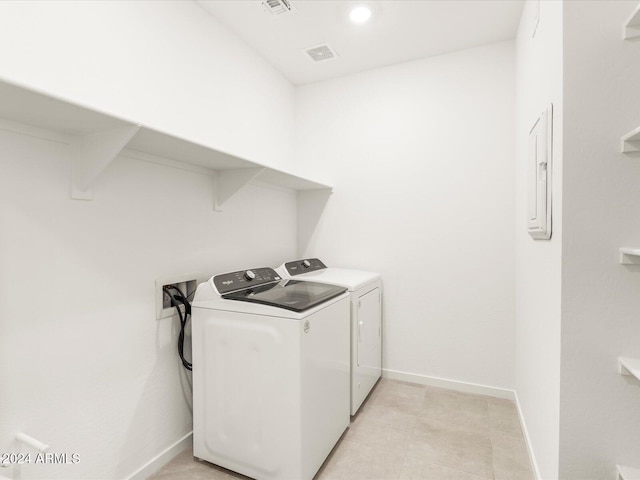 laundry room with washing machine and dryer and light tile patterned floors