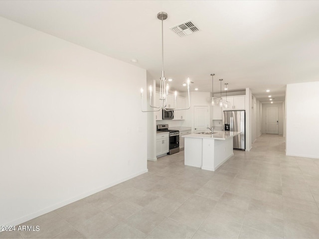 kitchen with white cabinets, hanging light fixtures, an island with sink, appliances with stainless steel finishes, and sink