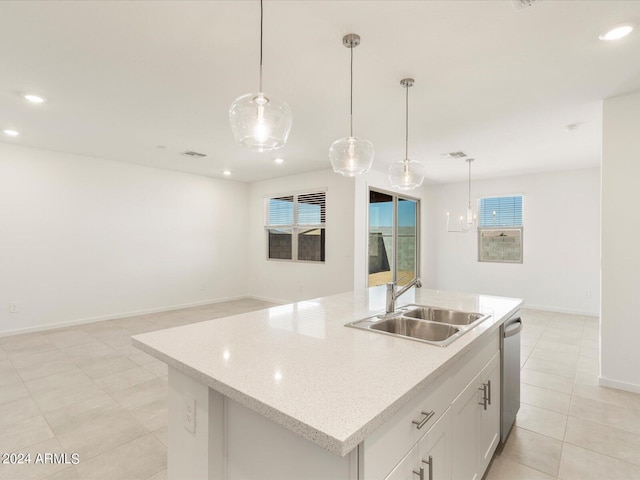 kitchen with hanging light fixtures, a center island with sink, sink, stainless steel dishwasher, and white cabinets